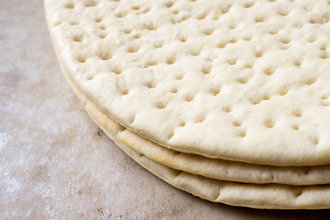 Frozen pizza dough on grey table